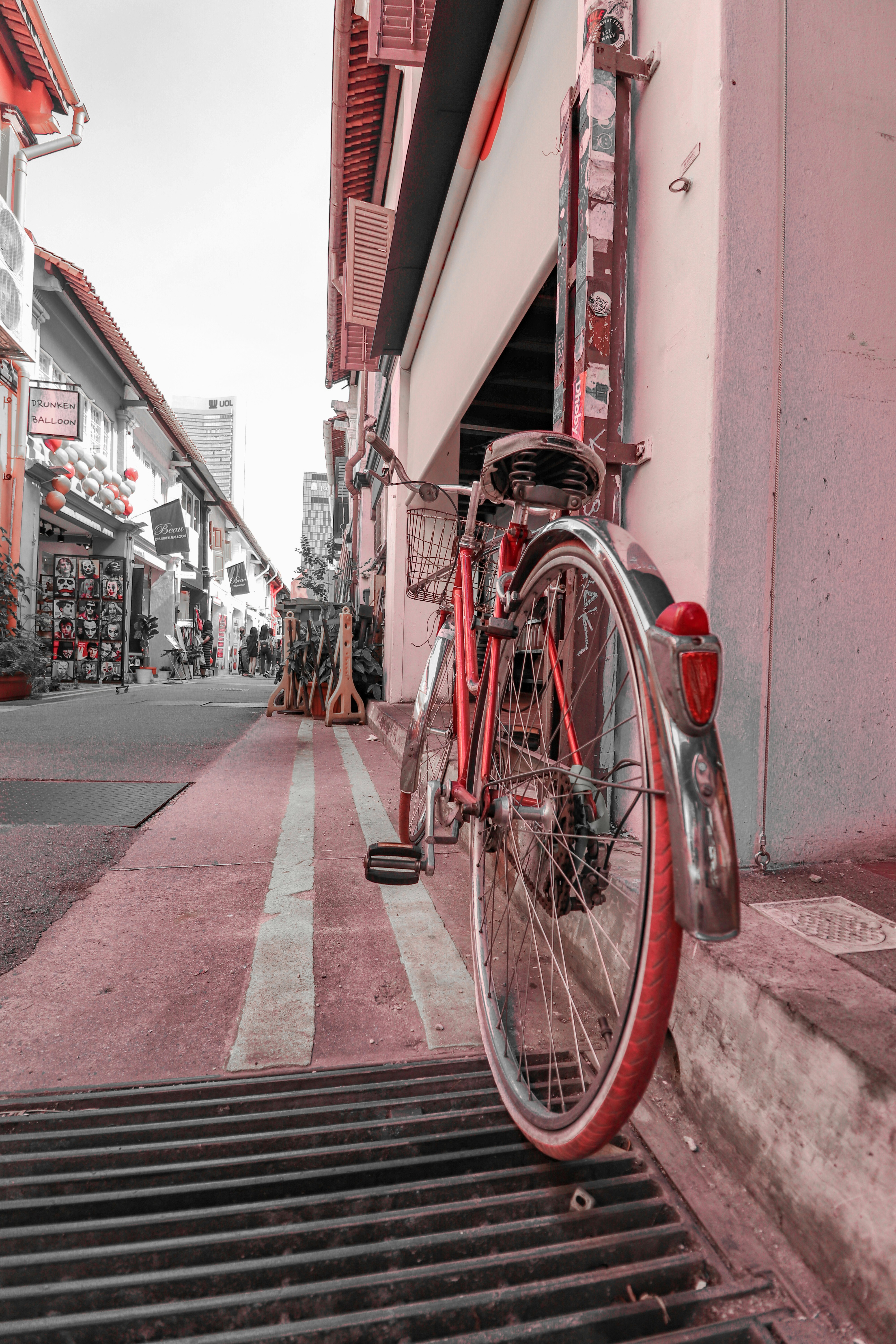 red city bike parked on sidewalk during daytime